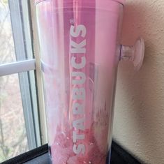 a pink blender sitting on top of a window sill