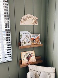 there are two books on the shelves in this small room with green walls and wood paneling