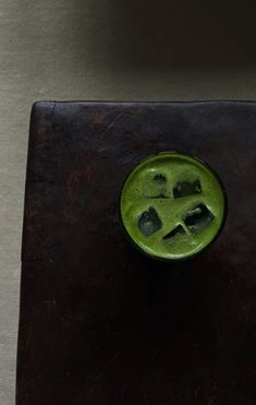 a green drink with ice cubes in it