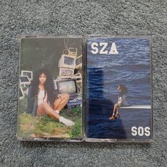 two cds sitting on top of a carpet next to each other in front of a body of water