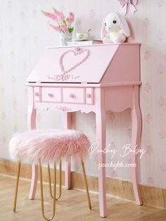 a pink desk with a heart on it and a stuffed animal sitting at the top