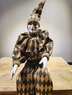 a clown doll sitting on top of a wooden table