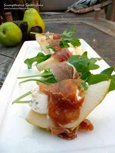 a white plate topped with apple slices covered in prosciutto and meats