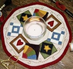 a candle is sitting on top of a table with scissors and other crafting supplies