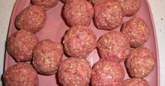 meatballs are arranged in a pink tray on a counter top, ready to be cooked