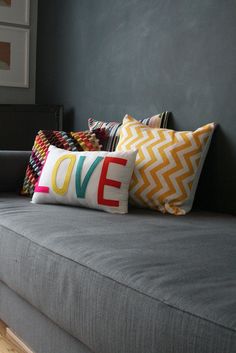 a gray couch with colorful pillows on it