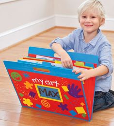 a young boy sitting on the floor with a toy box in front of him that says try my max