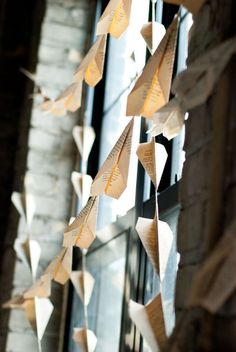 some paper birds are hanging from a window