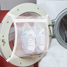 a person's shoe is in the front of a washing machine