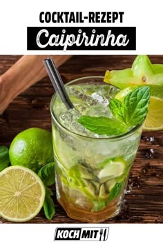 a cocktail with limes and mint on the side