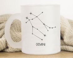 a white mug with the zodiac sign gemini on it