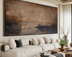 a living room filled with white furniture and a large painting on the wall above it