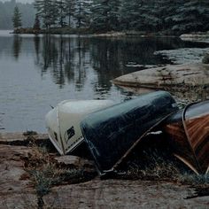 two canoes sitting on the shore of a lake