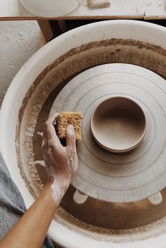 a person holding a piece of pottery in their hands