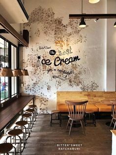 a restaurant with wooden tables and chairs in front of a wall that has ice cream written on it