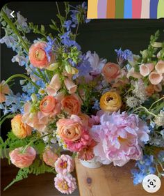 a vase filled with lots of different colored flowers