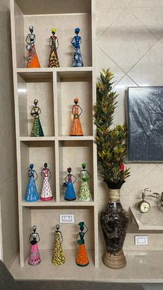 there are many figurines on the shelves in this bathroom display case, which is decorated with flowers and other decorative items