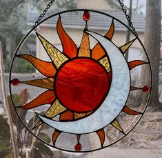 a stained glass sun and moon hanging on a window