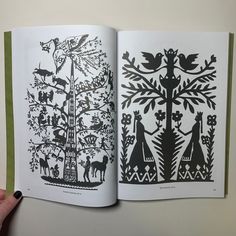 an open book with black and white designs on it, showing the inside pages that have been cut out