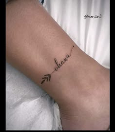 a woman's foot with the word mama written on it and an arrow tattoo