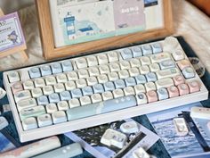 a computer keyboard sitting on top of a bed next to a wooden frame and pictures