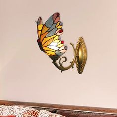 a wall mounted light with a butterfly on it