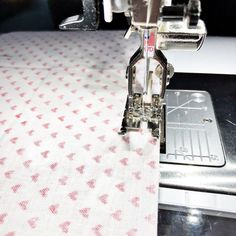 the sewing machine is working on the table cloth with it's needle and thread