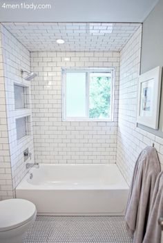 a bathroom with white and gray tiles on the walls