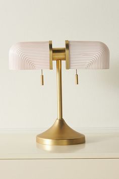 a lamp that is sitting on top of a table in front of a white wall