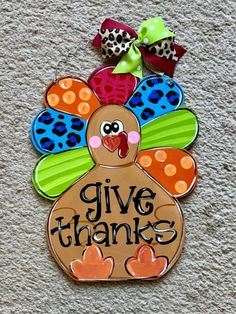 a wooden turkey with the words give thanks painted on it