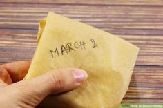 a person holding a piece of yellow paper with the word march written on it in black ink