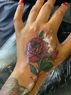 a woman's hand with a rose tattoo on it