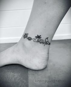 a black and white photo of a foot with tattoos on the toes, palm trees and flowers