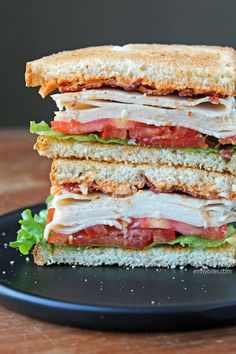 a cut in half sandwich sitting on top of a black plate