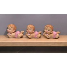 three little figurines sitting on top of a wooden table