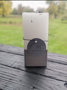 an empty box sitting on top of a wooden table with grass in the back ground