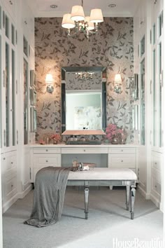 a bathroom with a bench, mirror and lights on the wall next to the sink