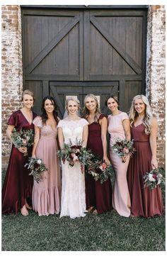 a group of women standing next to each other in front of a wooden barn door