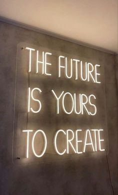 a neon sign that says the future is yours to create on it's wall