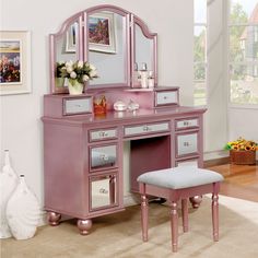 a pink vanity with mirror and stool in a room