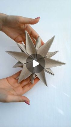 two hands are holding an origami star