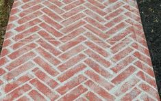 an orange and white brick walkway in the grass