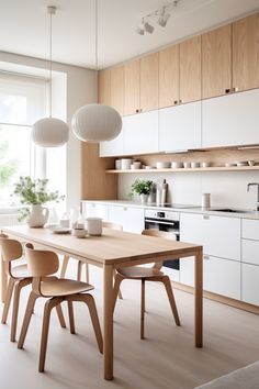 Modern kitchen with light wood furniture and white cabinets. Hanging round ceramic ceiling lamps over the dinig table. Japandi Kitchen, Scandi Kitchen, Kitchen Design Modern White, Modern Kitchen Design Luxury, Kitchen Design Ideas, Kitchen Cabinet Design