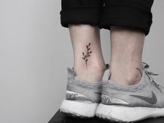 a woman's foot with a small flower tattoo on her left side calfocks