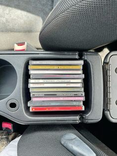 a bunch of cds are in the compartment of a car