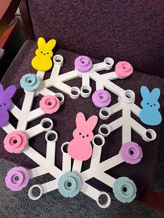 paper snowflakes with buttons and bunnies on them sitting on a chair