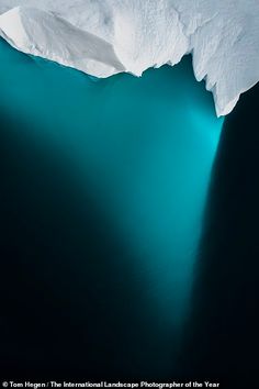 an iceberg in the middle of blue water with snow on it's sides