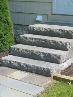 the steps are made of stone and have been placed in front of a house