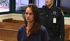 a woman standing in front of a police officer next to her is looking at the camera