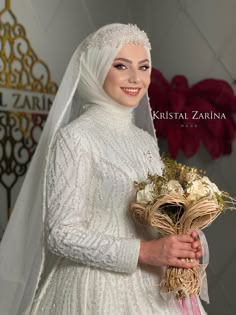 a woman in a white wedding dress holding a bouquet of flowers and smiling at the camera